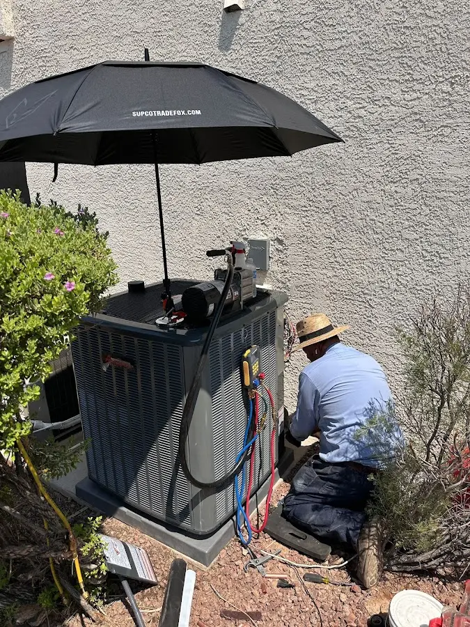 HVAC technician performing outdoor AC maintenance in Morganton