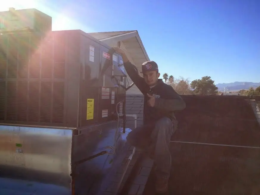 HVAC technician performing AC Tune-Up on a rooftop unit in Morganton